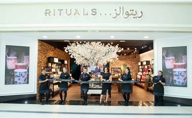 Staff Cutting Ribbon Outside Rituals Store for New Store Opening